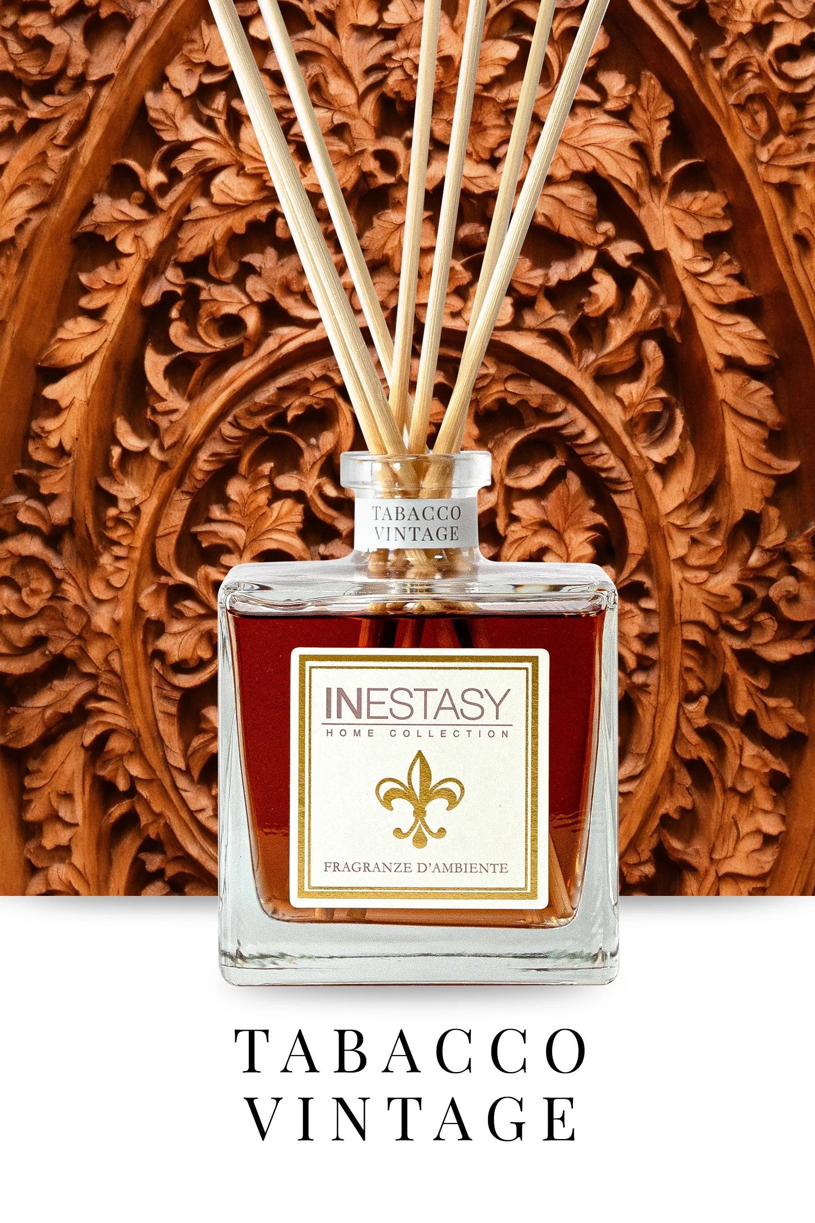 Una bottiglia di tabacco vintage con diffusore a bastoncini è appoggiata su un tavolo di fronte a una parete di legno.