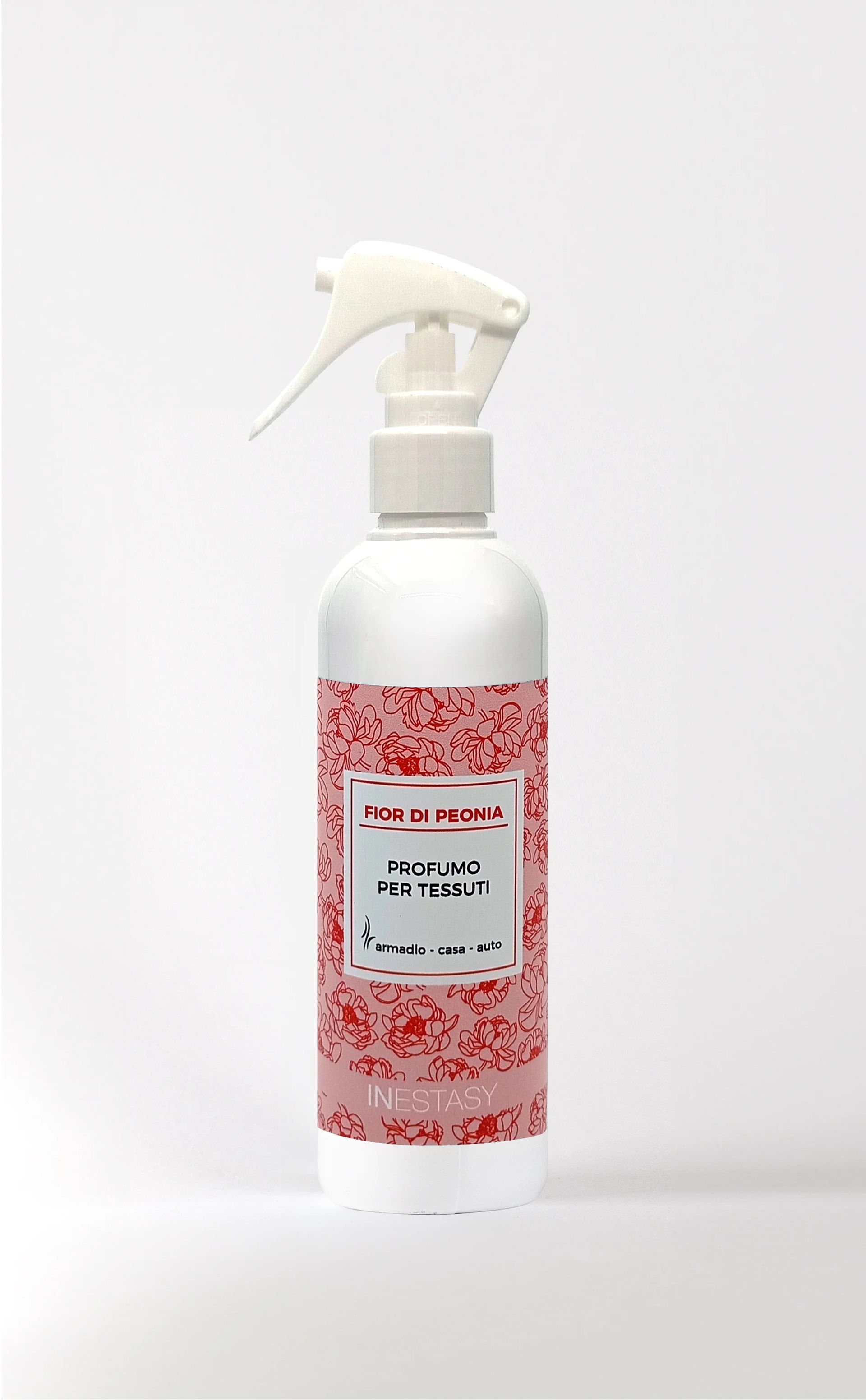 Una bottiglia spray bianca con un'etichetta rossa su una superficie bianca.