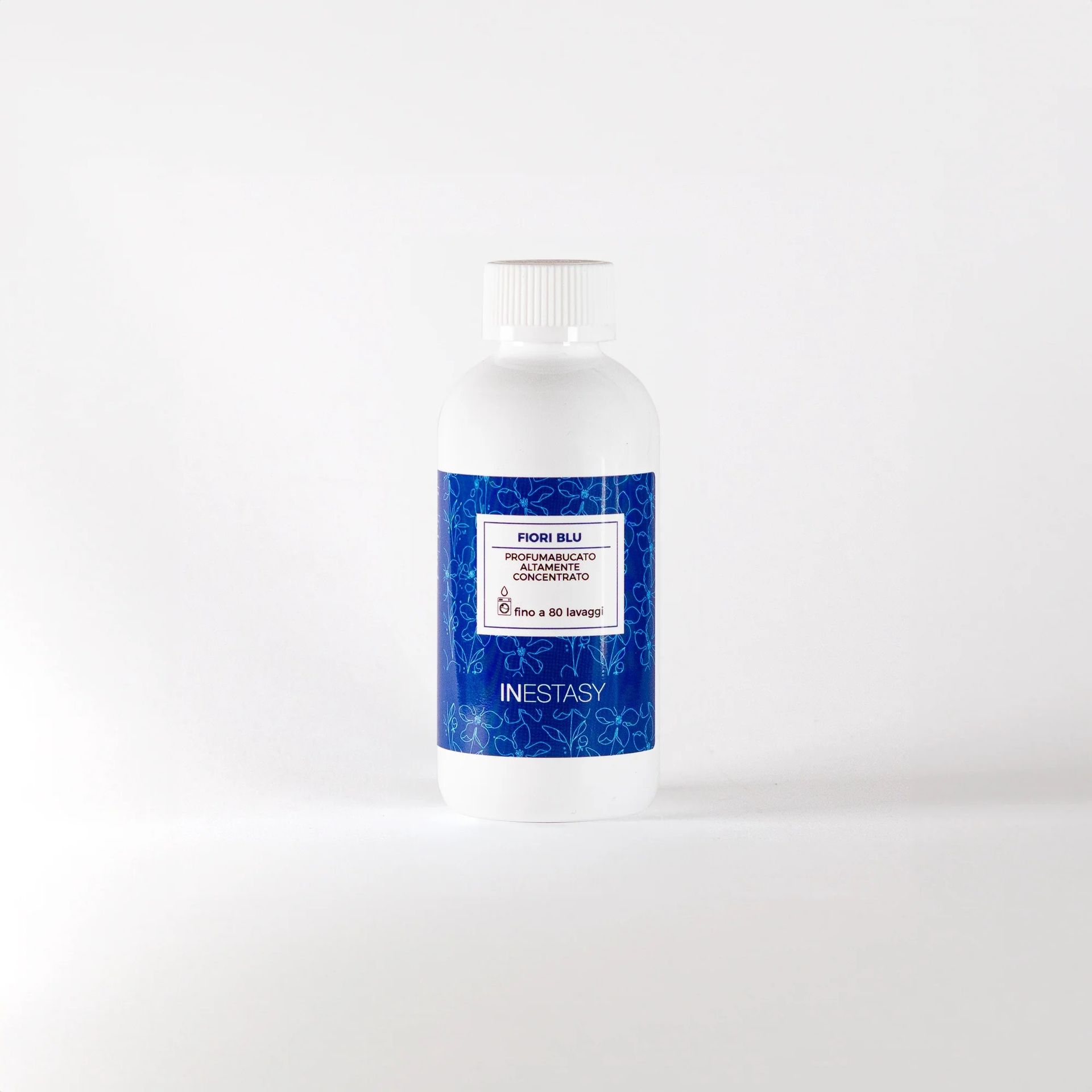 Una bottiglia bianca con un'etichetta blu è appoggiata su una superficie bianca.