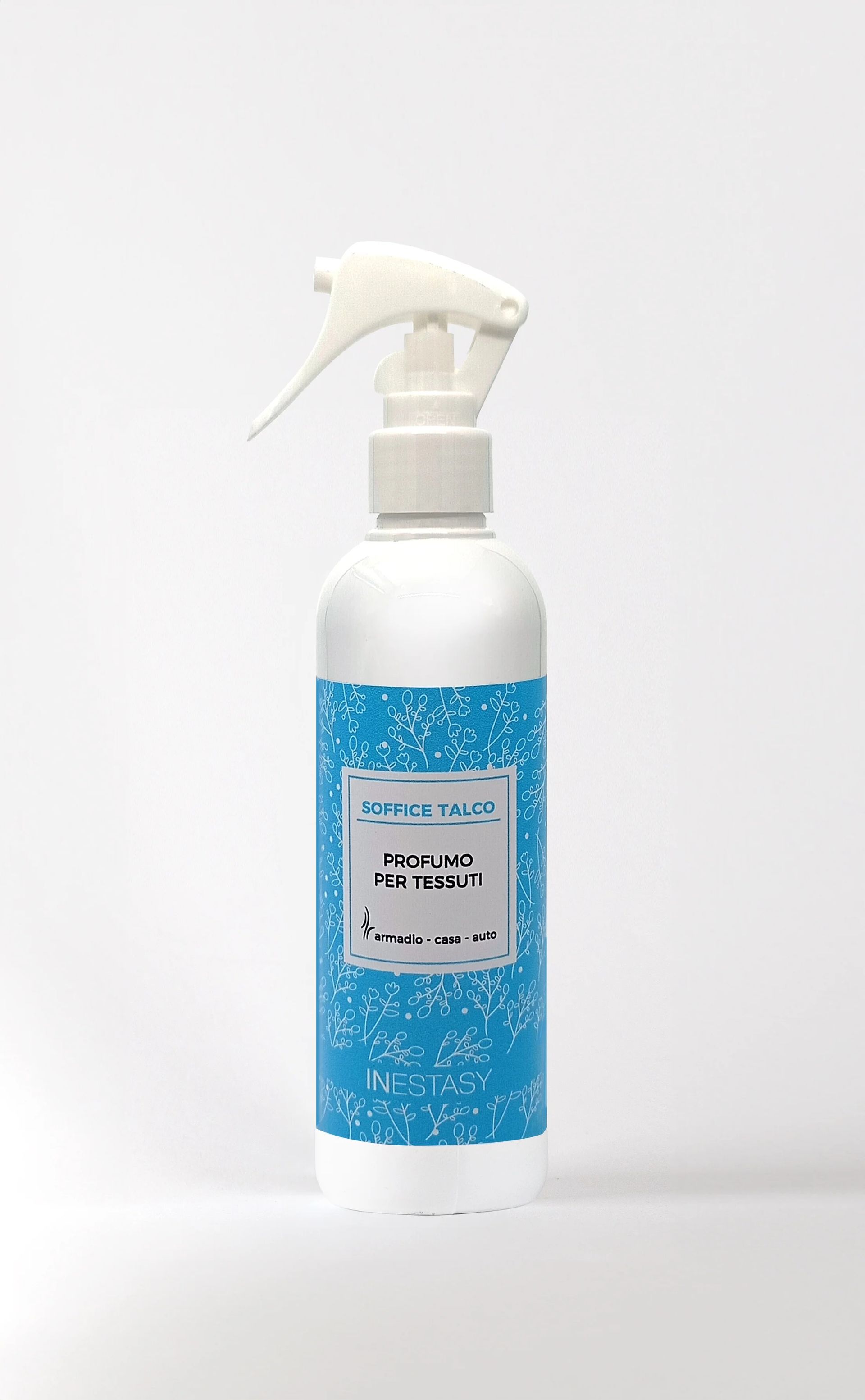 Una bottiglia spray bianca con un'etichetta blu è appoggiata su una superficie bianca.