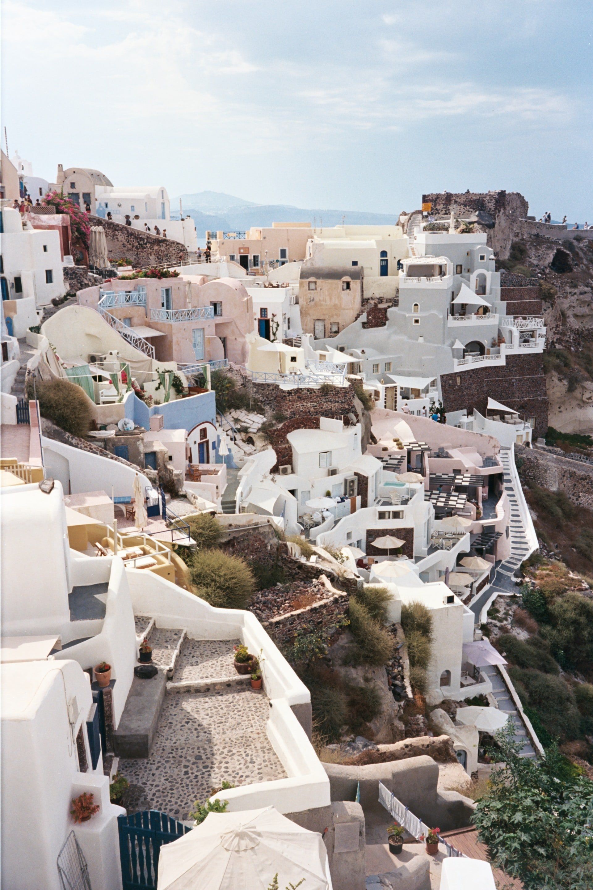 An aerial view of a small town on a hill overlooking the ocean.
