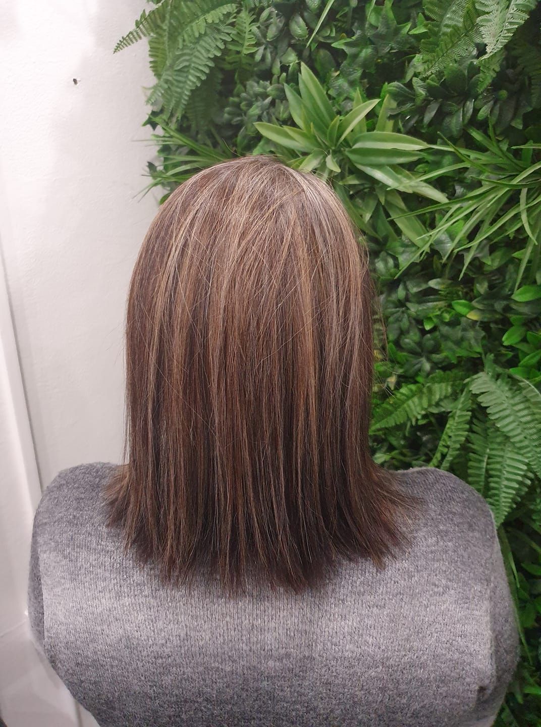 Brown Hair With Blonde Highlights, Ends at the Shoulders, in Front of a Green Wall — ClaireAbella Hair Studio In Kariong, NSW