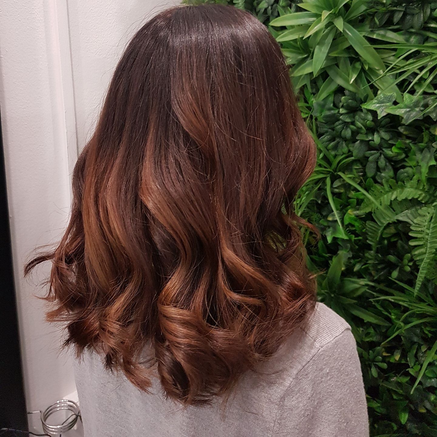 Woman with wavy, dark brown hair with copper highlights — ClaireAbella Hair Studio In Kariong, NSW