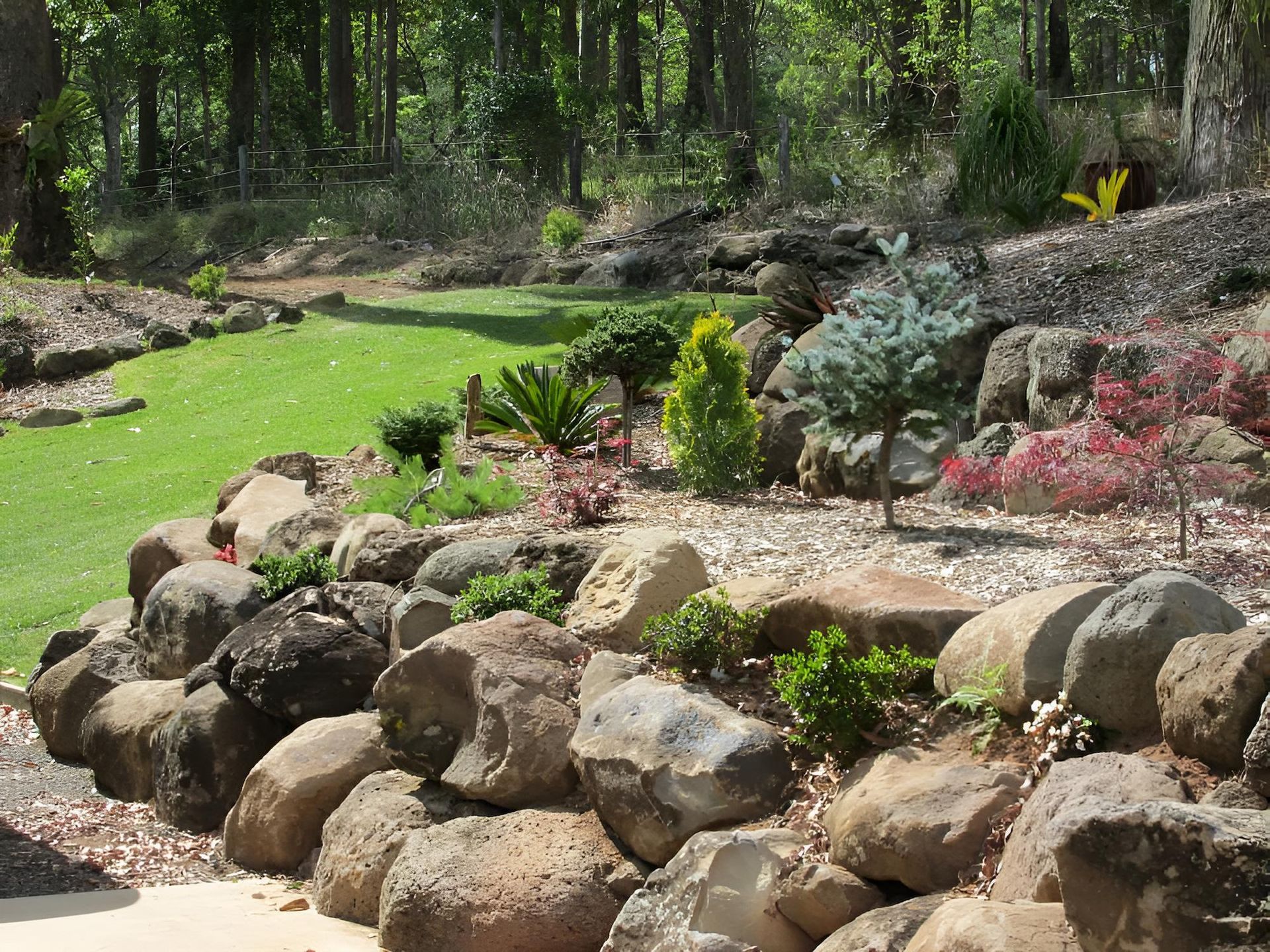 A Rock Garden With a Lush Green Field in the Background — Highfields Landscape Supplies In Dalby, QLD