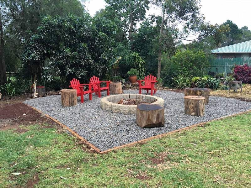 A Fire Pit With Red Chairs Around It in a Yard — Highfields Landscape Supplies In Meringandan, QLD
