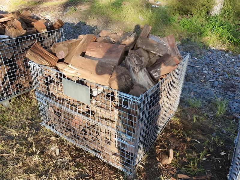A Metal Crate Filled With Wood is Sitting on the Ground — Highfields Landscape Supplies In Toowoomba, QLD