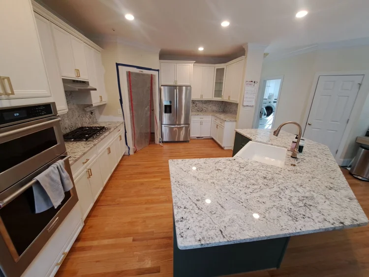 Newly renovated kitchen with white cabinets, granite countertops, and wood floors.