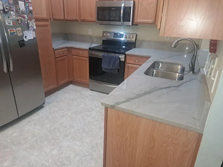 Kitchen with stainless steel appliances, light gray countertops, and wooden cabinets.