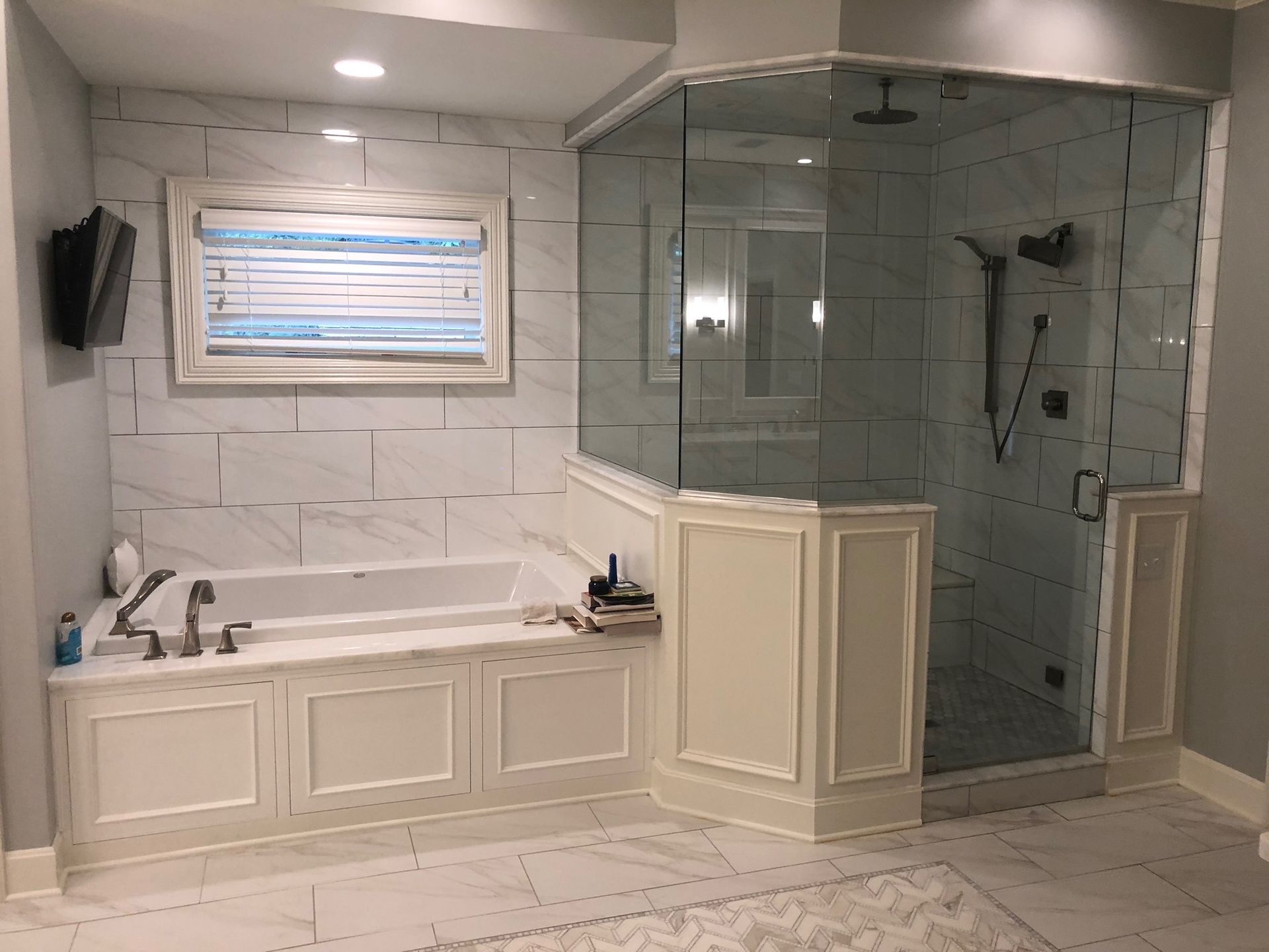 Luxury marble bathroom with freestanding tub and glass shower enclosure.