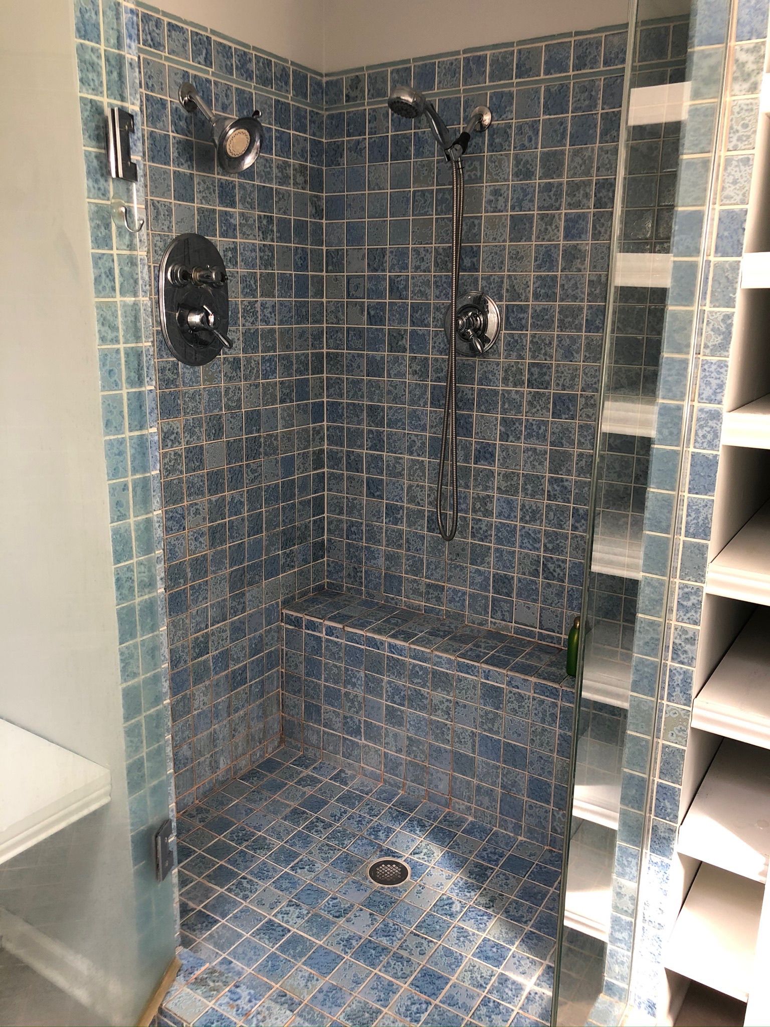 A bathroom with a walk in shower with a glass door