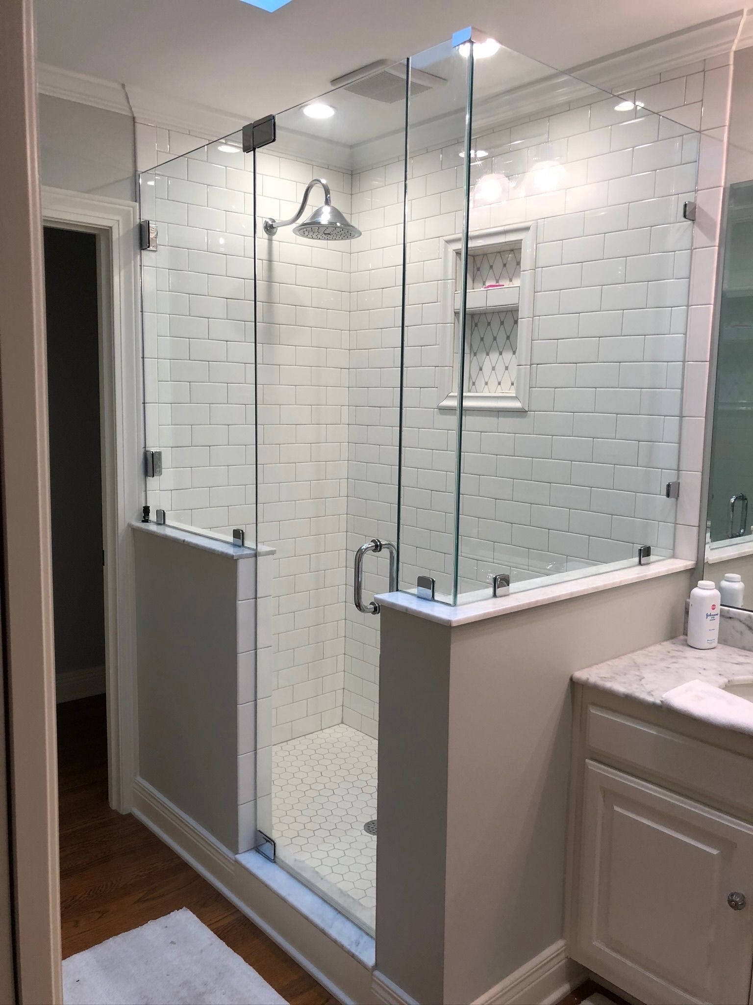 A bathroom with a walk in shower and a sink.
