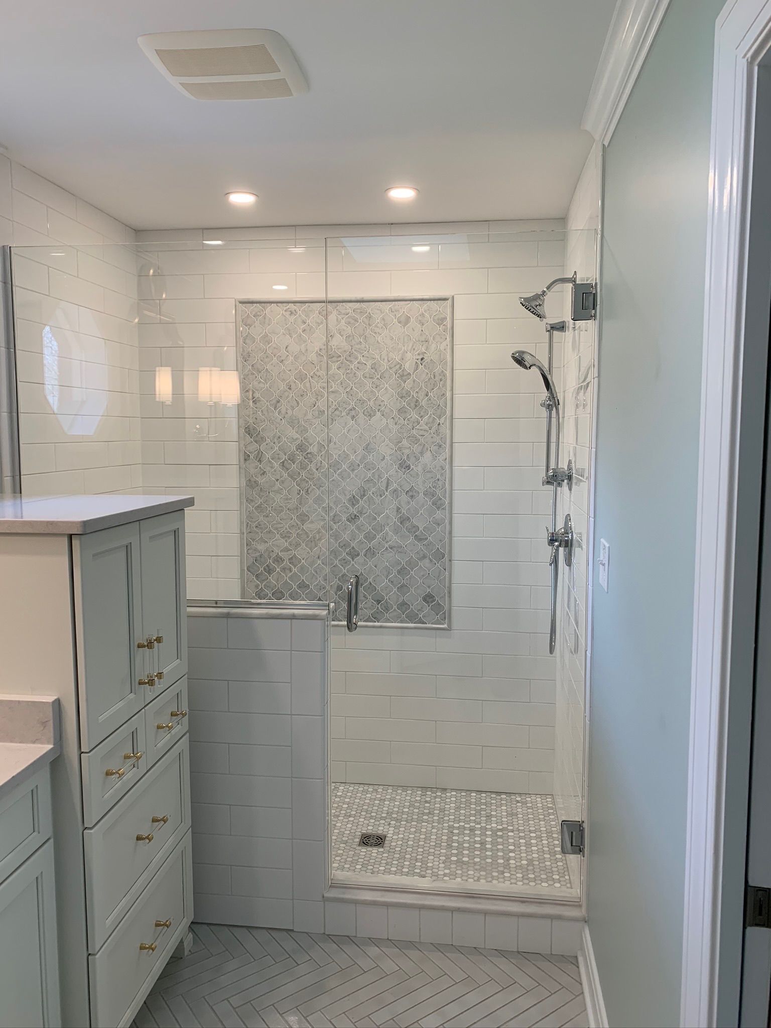 A bathroom with a walk in shower and a sink.