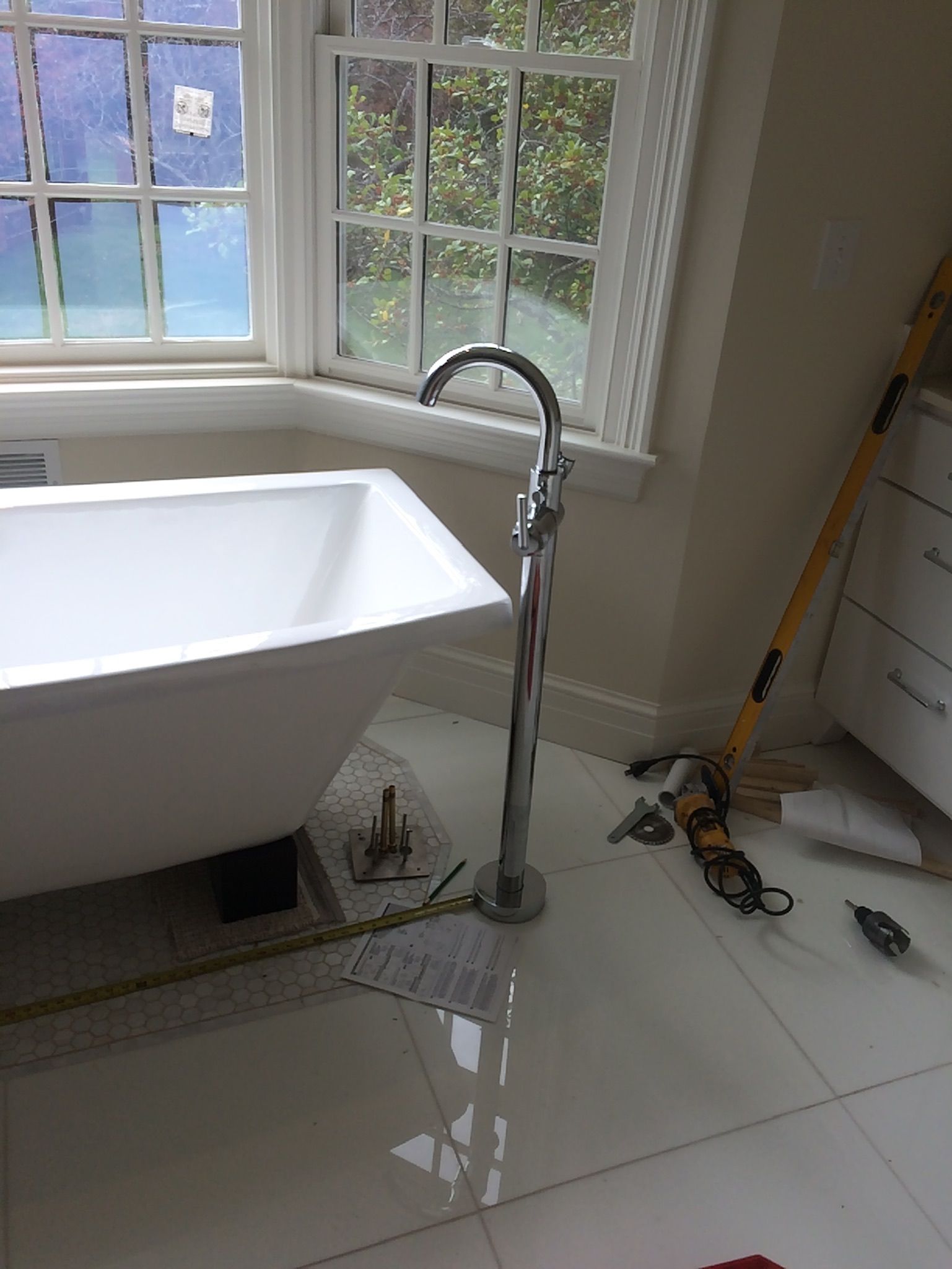 A bathtub is sitting in a bathroom next to a window.