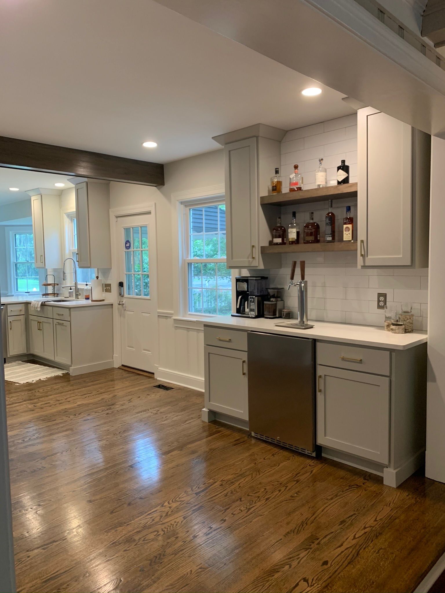 A kitchen with white cabinets , stainless steel appliances , and hardwood floors.