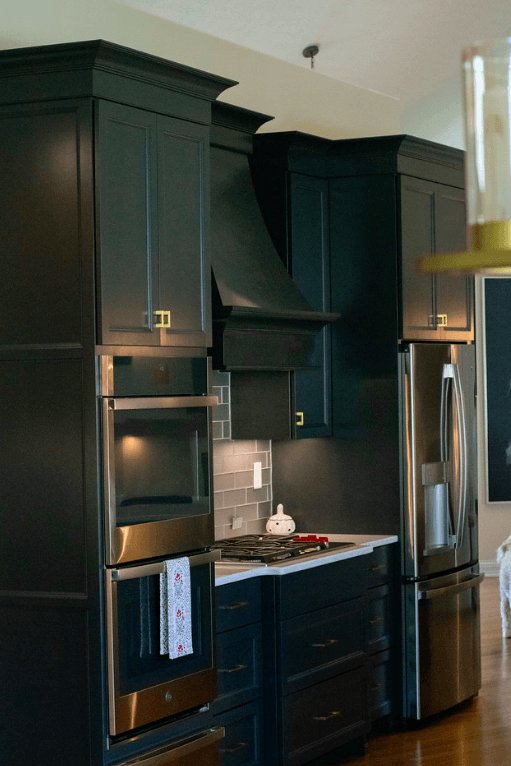 A kitchen with black cabinets and stainless steel appliances