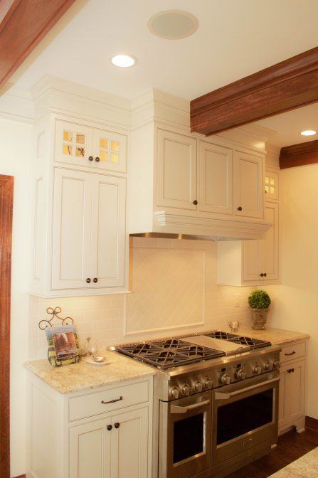A kitchen with white cabinets and a stove top oven