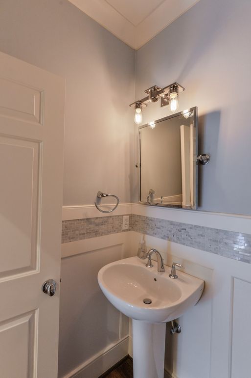 A bathroom with a pedestal sink and a mirror