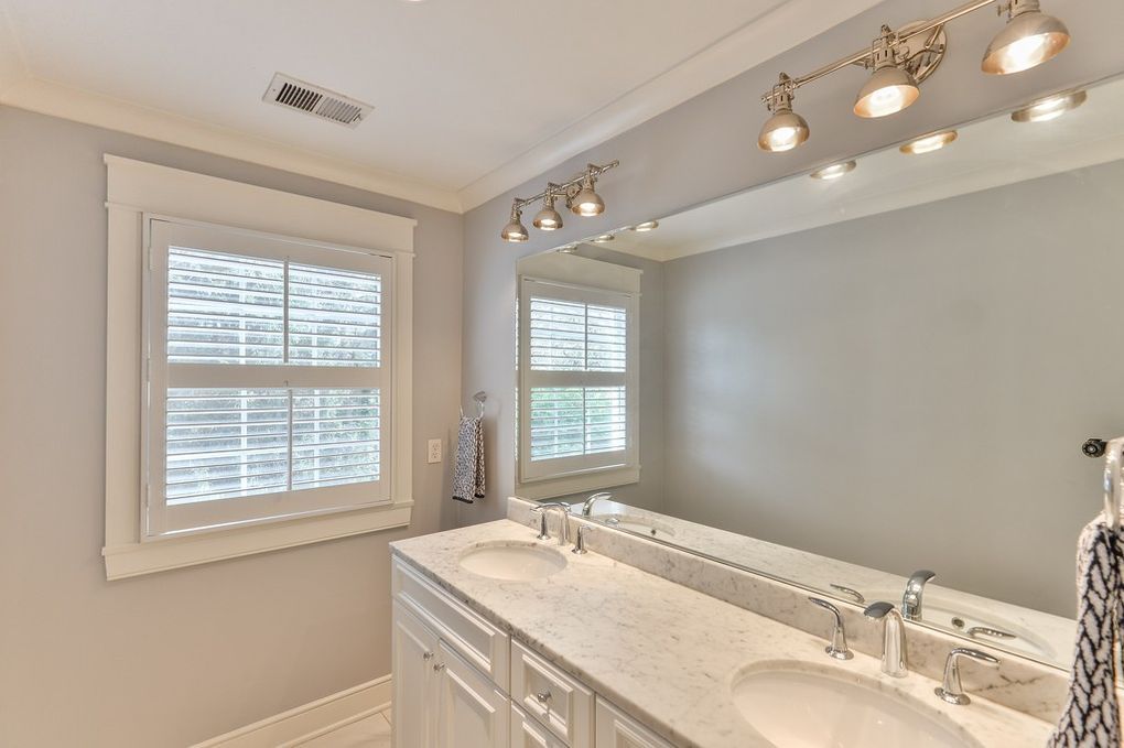 A bathroom with two sinks and a large mirror.