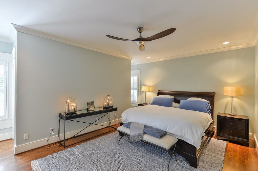 A bedroom with a large bed and a ceiling fan.