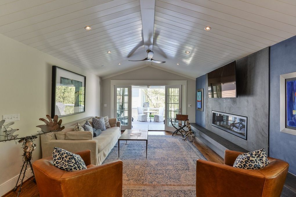 A living room with a couch , chairs , and a fireplace.