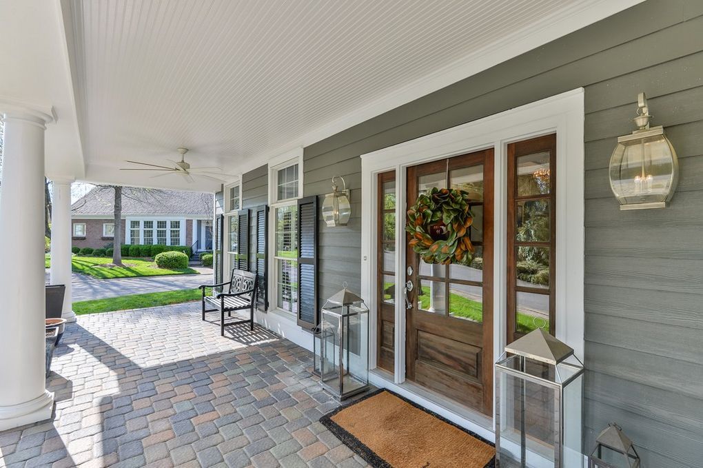 The front door of a house with a porch and a wreath on it.