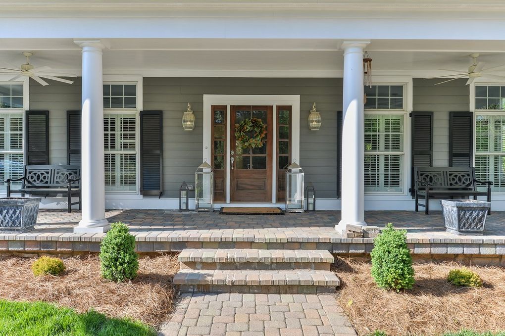 A large porch with steps leading to the front door of a house.