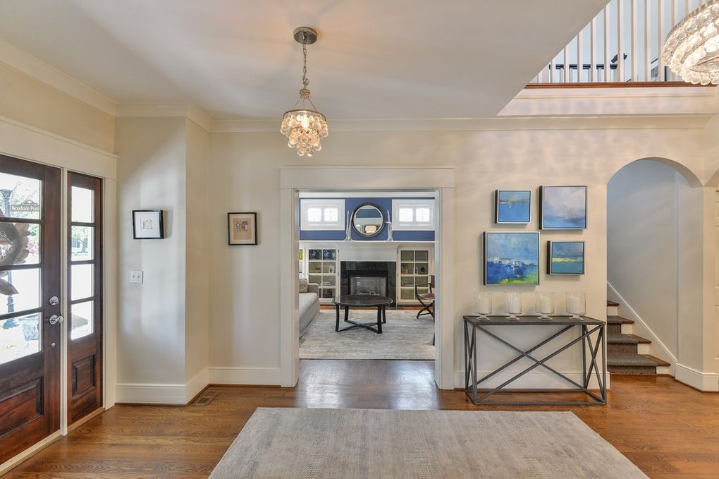 A living room with a fireplace and stairs in a house