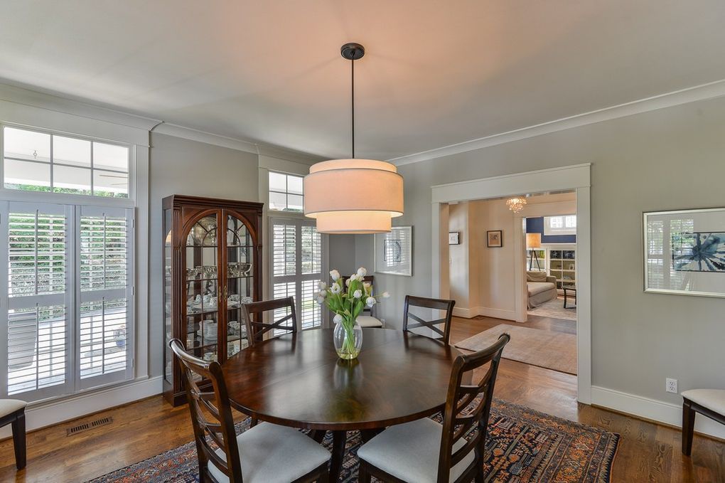 A dining room with a round table and chairs and a chandelier.