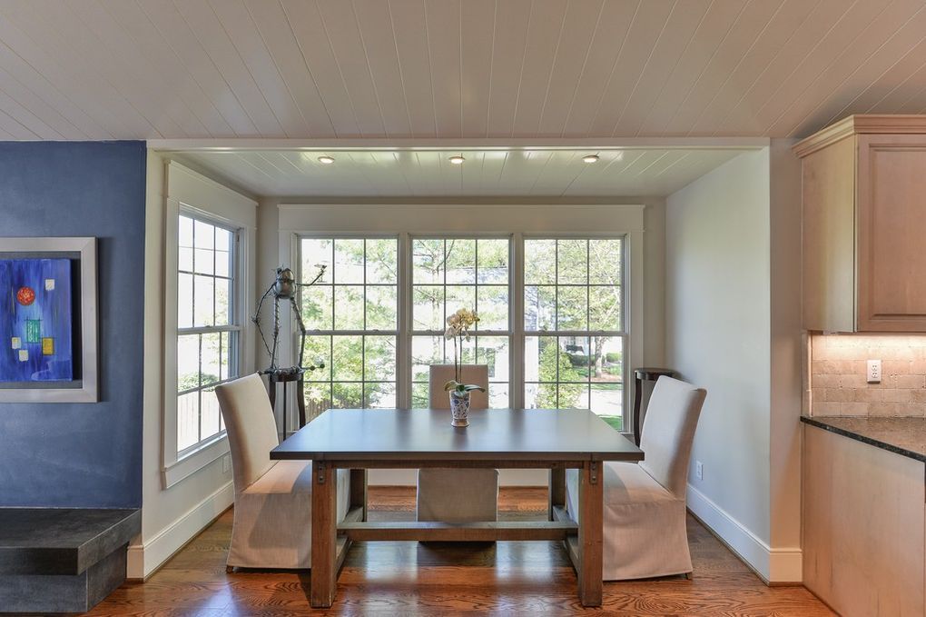 A dining room with a table and chairs and a large window