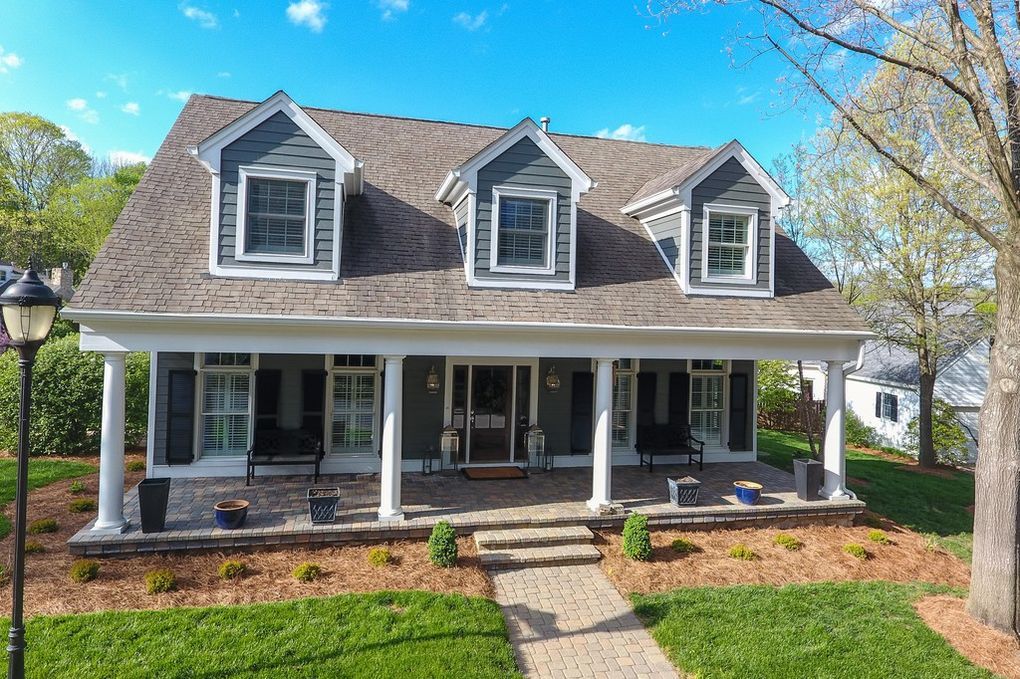 A large house with a large porch on a sunny day.