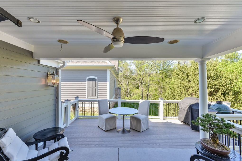 There is a ceiling fan on the porch of a house.