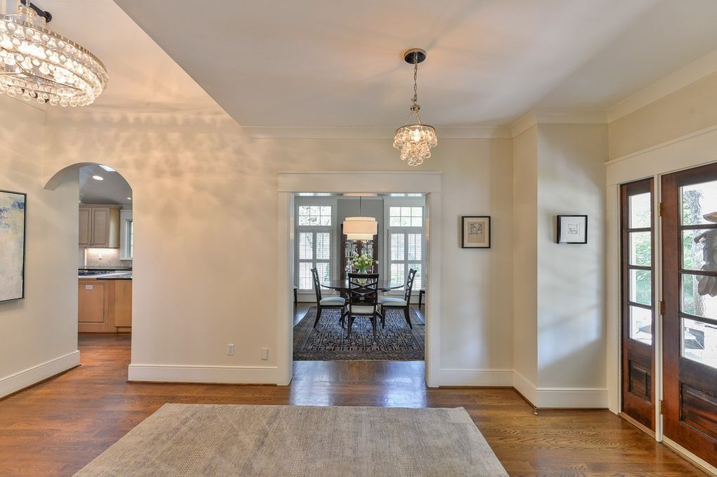 A living room with hardwood floors and a chandelier hanging from the ceiling.