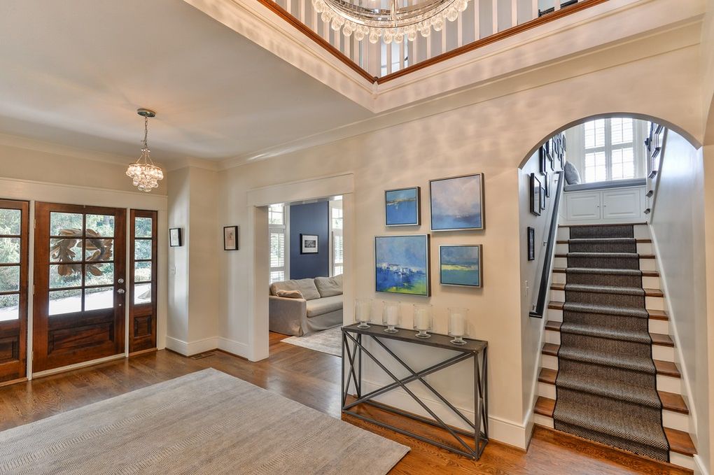 A large hallway with stairs leading up to the second floor of a house.