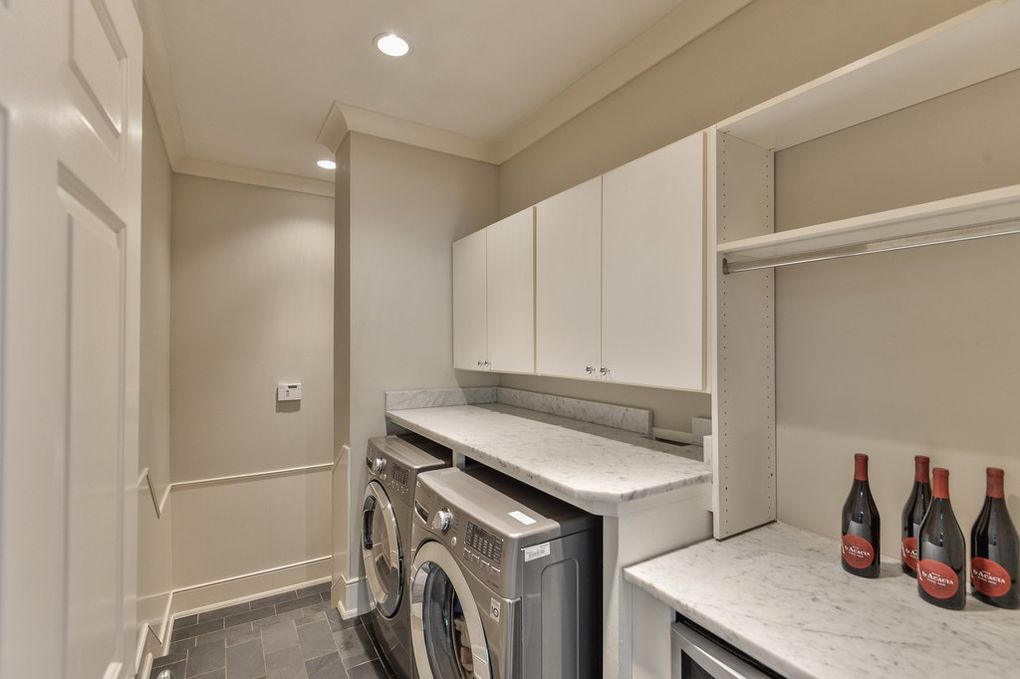 A laundry room with a washer and dryer and bottles of detergent.