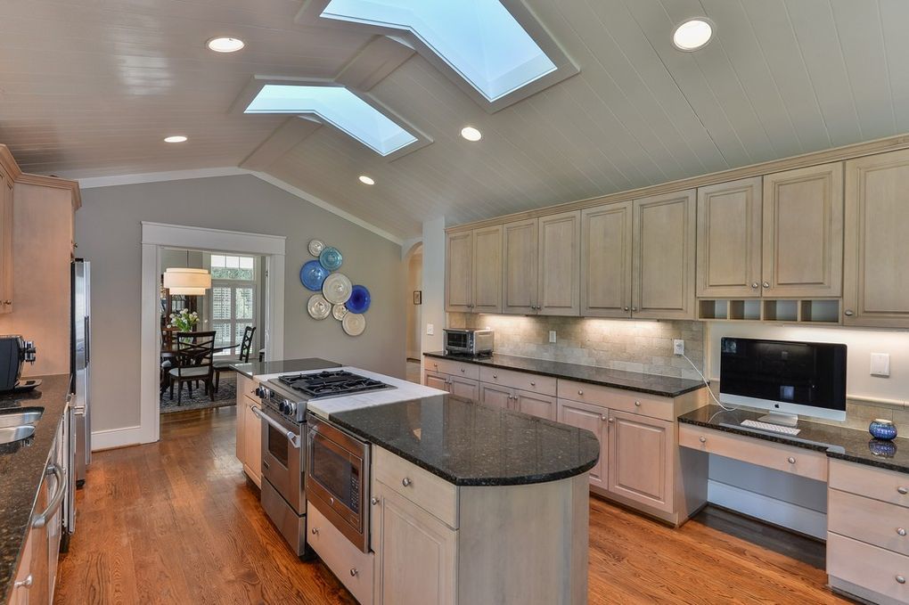 A kitchen with a large island and skylights on the ceiling.