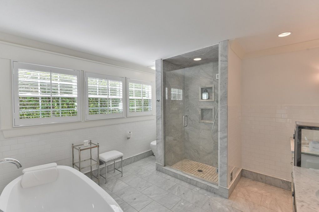 A bathroom with a tub and a walk in shower.