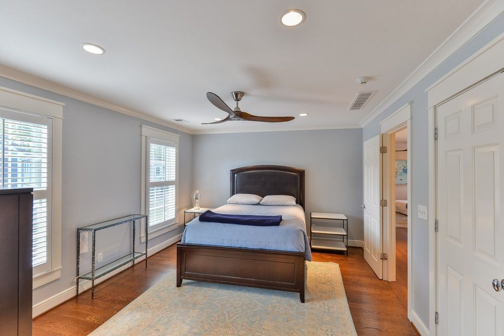 A bedroom with a bed and a ceiling fan
