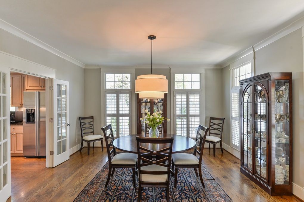 A dining room with a round table and chairs and a rug.