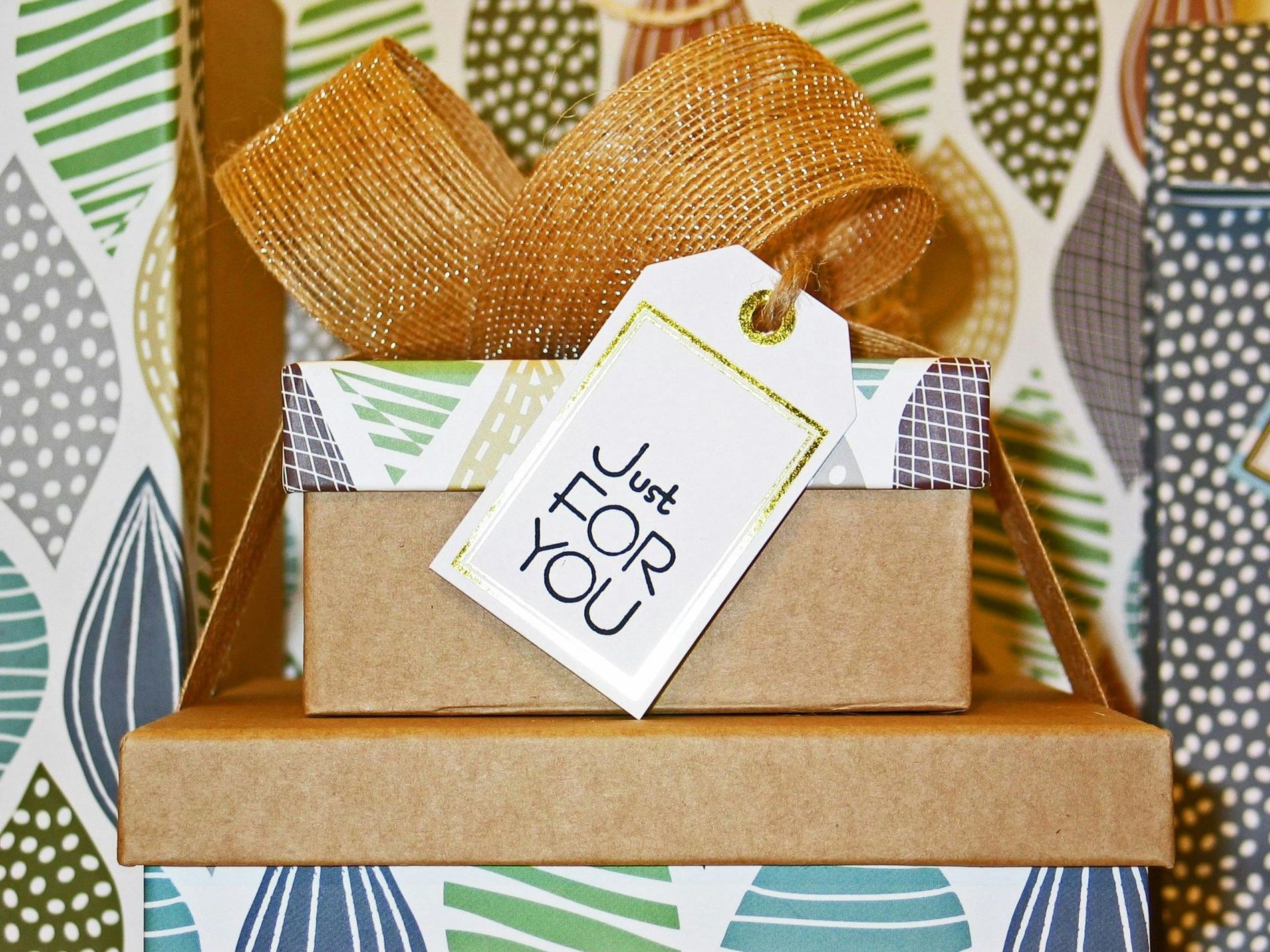 Gift boxes stacked with a gold ribbon and a 