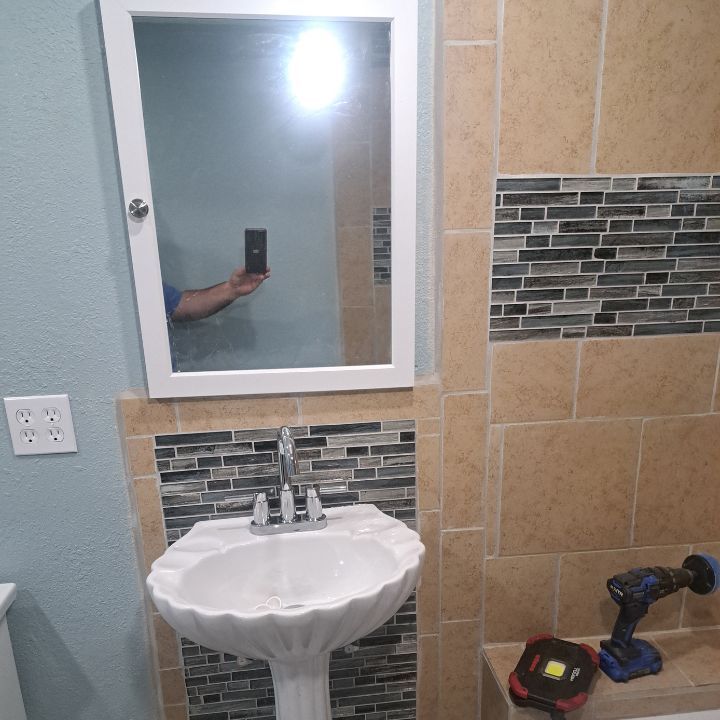 A renovated bathroom with a sink , mirror , and toilet.
