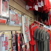 Arkansas State apparel hanging in a sports merchandise store, with red shirts and signs.