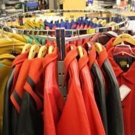 Racks of red and black jackets hanging on circular clothing displays in a store