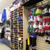Retail store aisle with colorful socks and accessories displayed on wall racks and shelves
