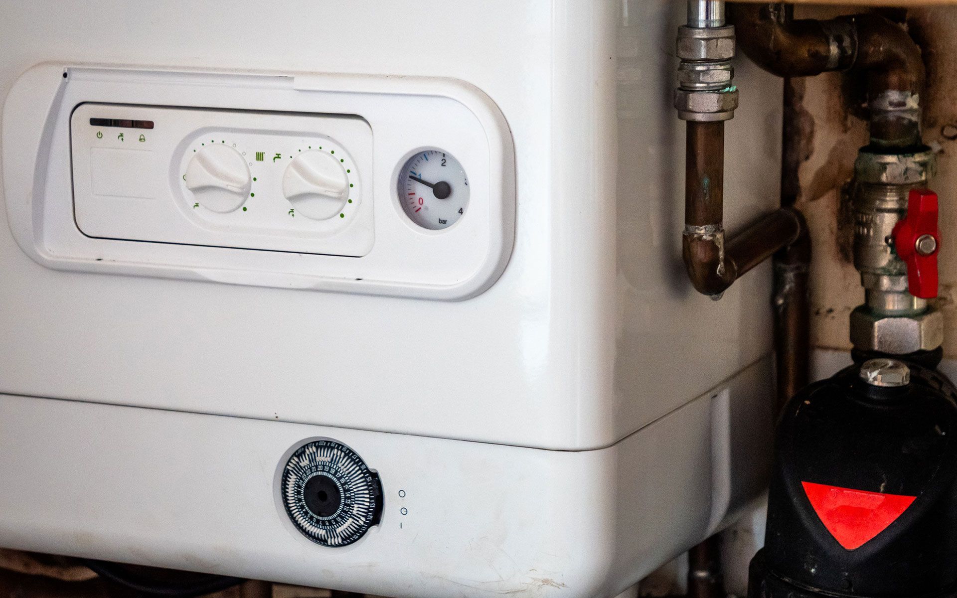 A close up of a boiler with a clock on it