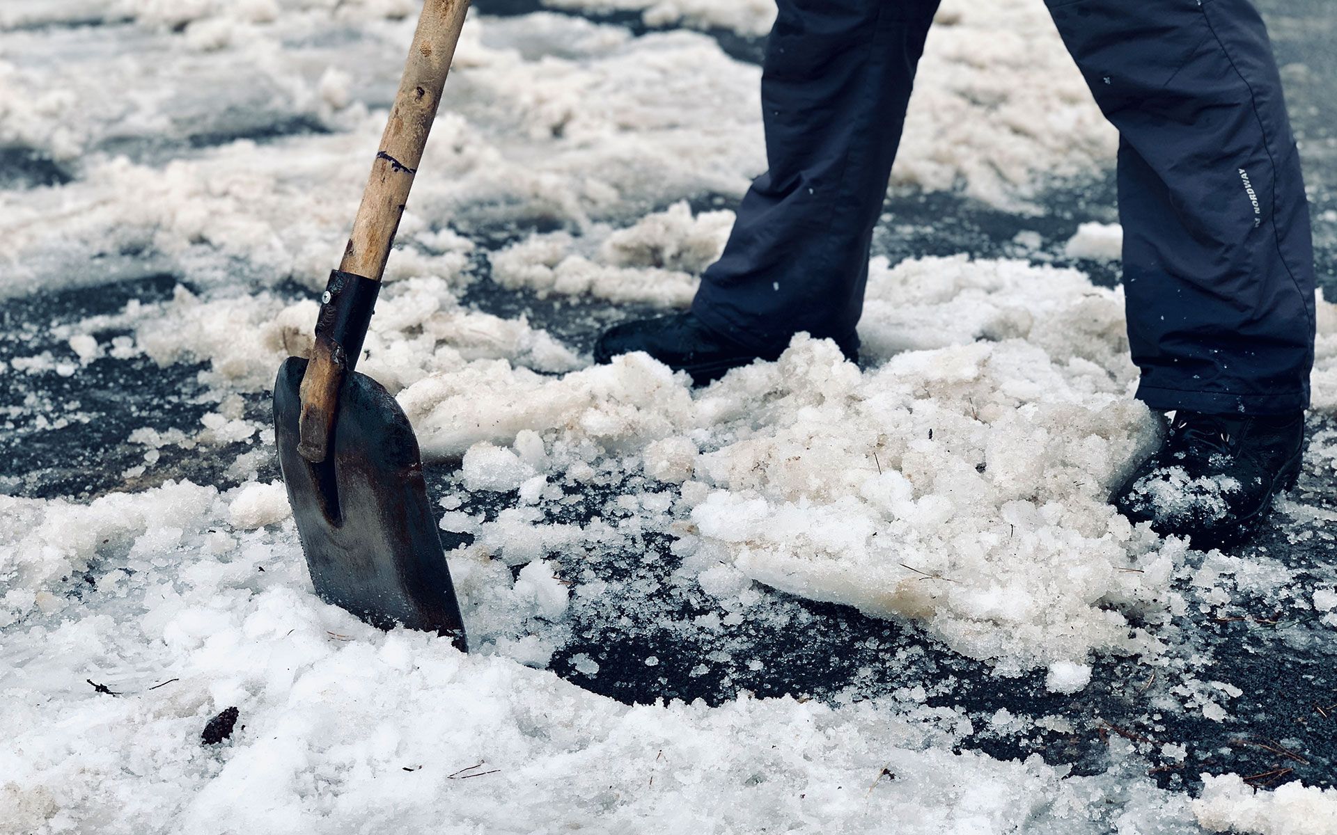 A person is shoveling snow from the ground with a shovel