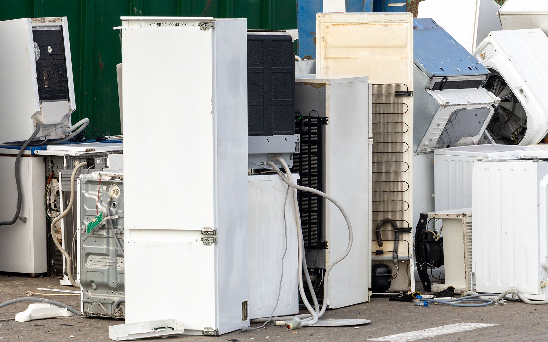 A bunch of old appliances are sitting on the ground.