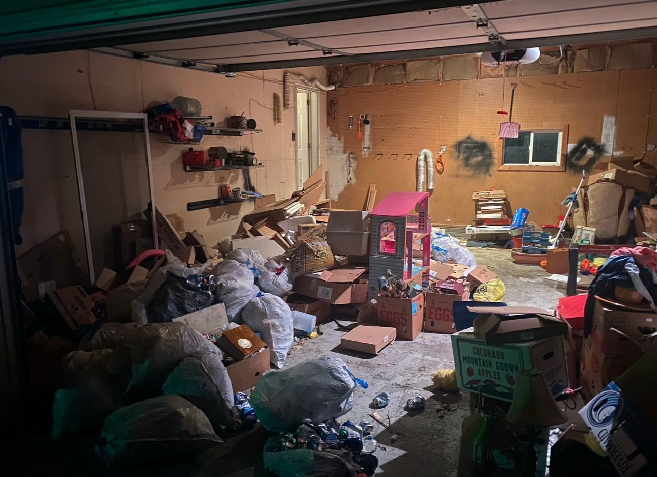 A couple of men are standing next to a garbage truck.