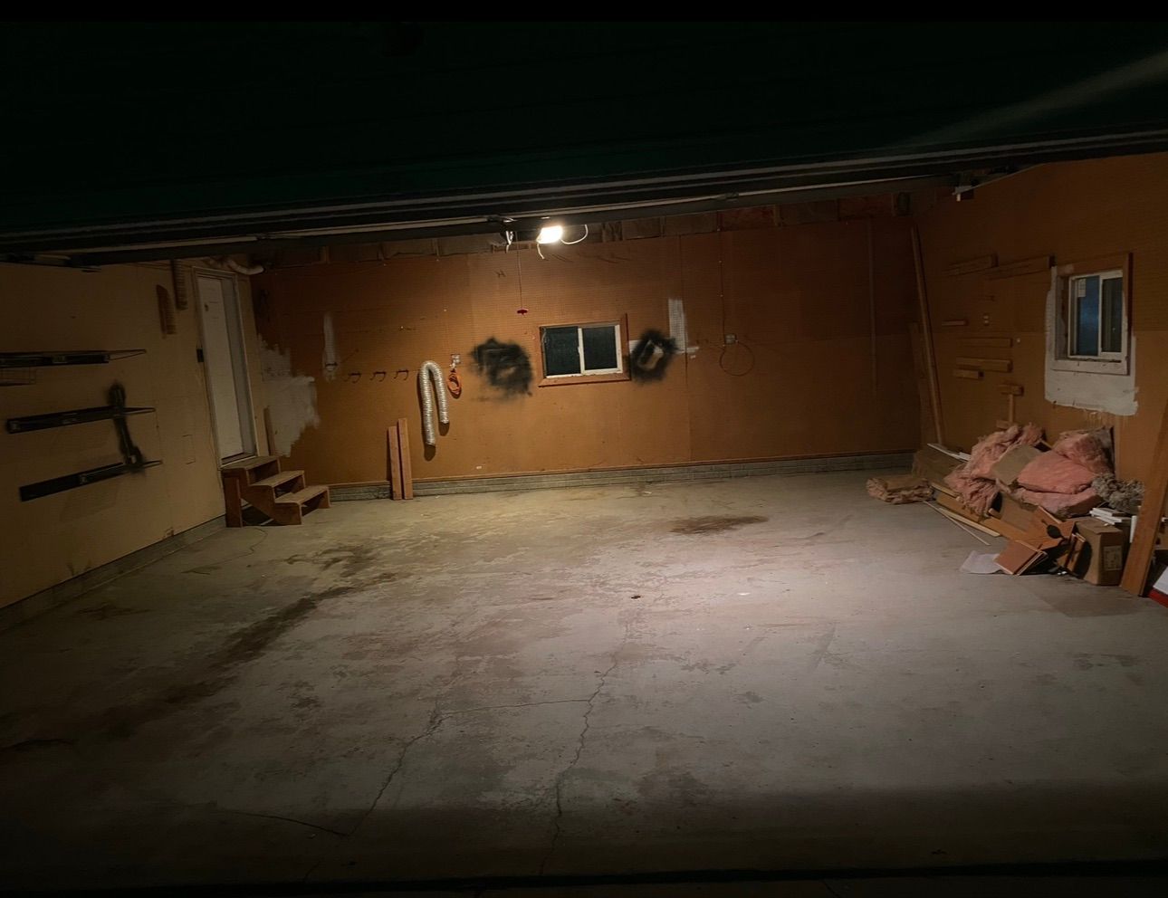 A blue dumpster filled with junk including a couch and chairs.