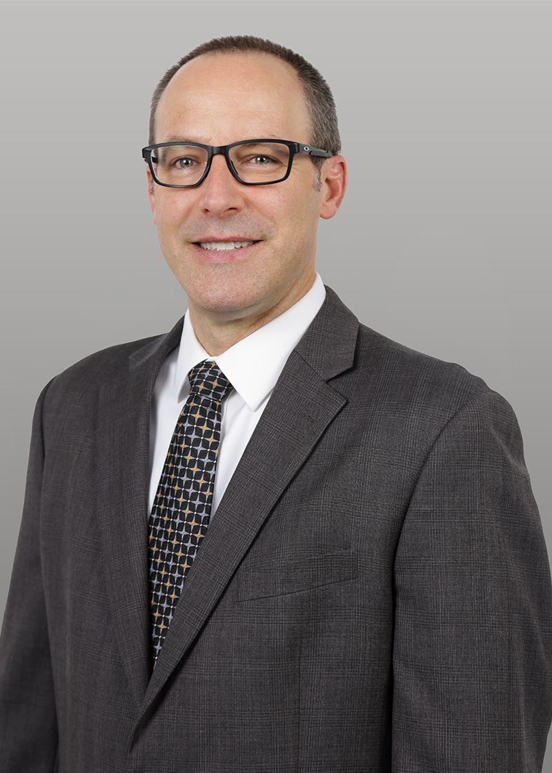 A man in a suit and tie is smiling for the camera.