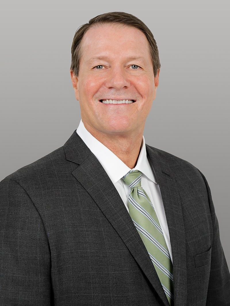 A man in a suit and tie is smiling for the camera.